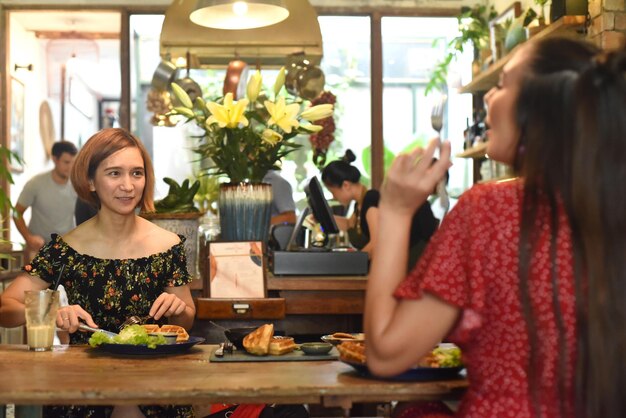 Jonge vrouwen communiceren met elkaar in café