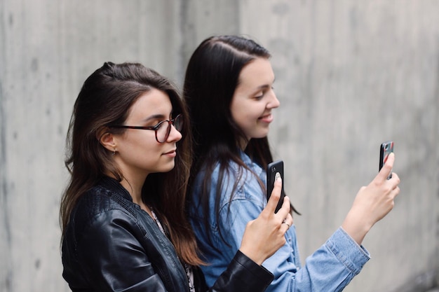 Jonge vrouwen die buiten mobiele telefoons gebruiken