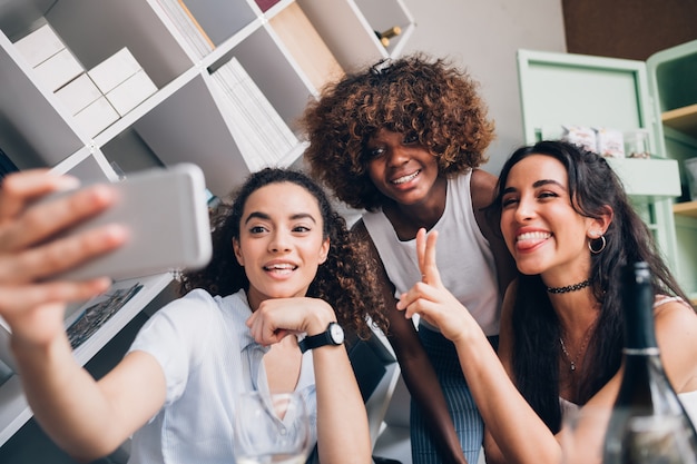 Jonge vrouwen die selfie maken en plezier hebben op een moderne locatie