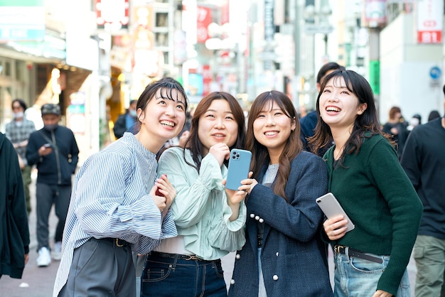 Jonge vrouwen die smartphones gebruiken in de stad