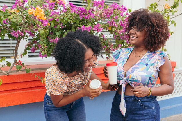 Jonge vrouwen drinken koffie op straat