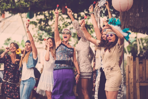 Jonge vrouwen en meisjes in vriendschap vieren allemaal samen en hebben plezier op een bio-natuurlijke plek. glimlacht en lachen voor groep hippies mensen alternatieve concept levensstijl