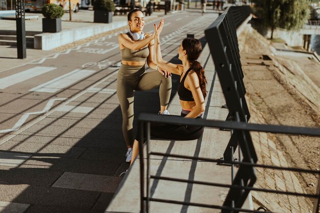 Jonge vrouwen in sportkleding oefenen op een rivierpromenade