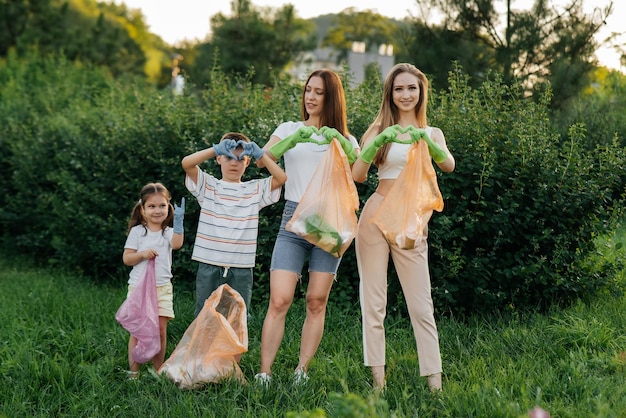 Jonge vrouwen met baby's tonen harten na het schoonmaken van afval in het park tijdens zonsondergang Milieuzorg afvalrecycling Afval sorteren