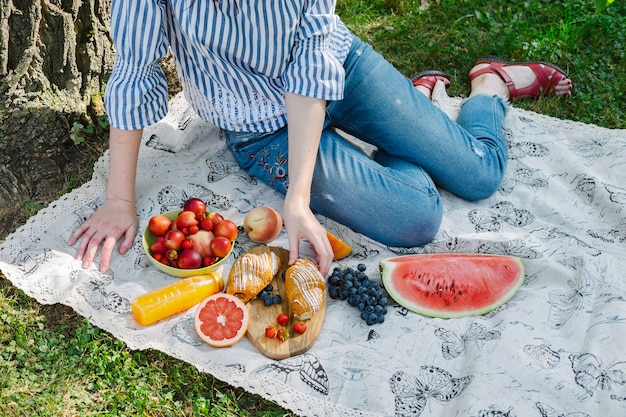 Jonge vrouwen op een picknick, reiken naar een croissant.