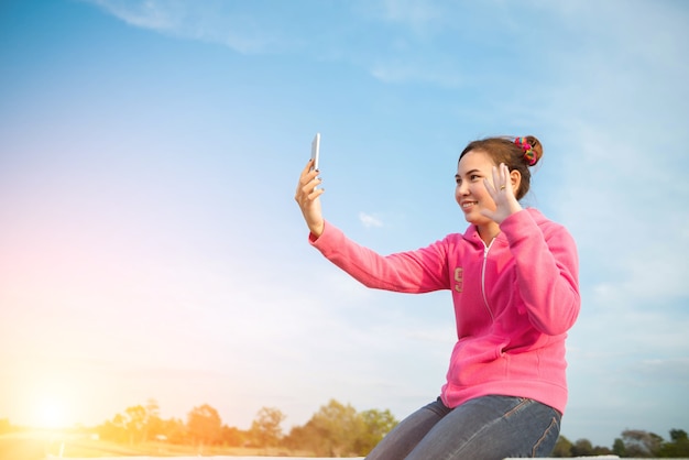 Jonge vrouwen zijn mooie selfie-hemel bij zonsondergang