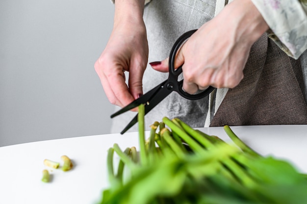 Jonge vrouwenbloemist die met verse bloementulpen werken, die boeket maken. witte achtergrond