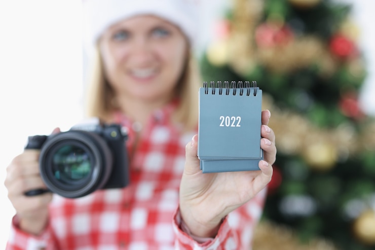 Foto jonge vrouwenfotograaf die kalender houdt voor veelgevraagd beroep van een fotograafconcept