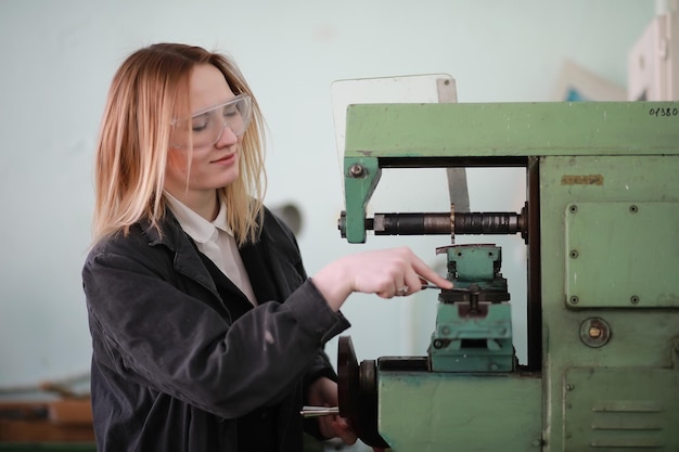 Jonge vrouweningenieur die bij werktuigmachine werkt