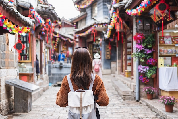 Jonge vrouwenreiziger die bij lijiang oude stad lopen in China, het concept van de Reislevensstijl