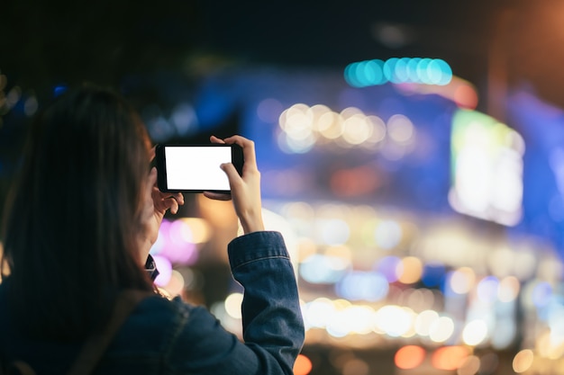 Jonge vrouwenreiziger die foto met mobiele telefoon neemt.