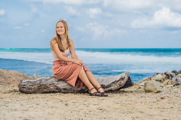 Jonge vrouwenreiziger op verbazend Melasti-strand met turkoois water, Bali Island Indonesia