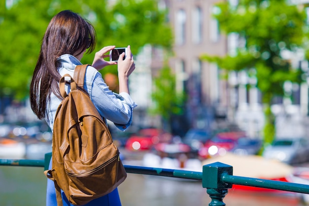 Jonge vrouwentoerist die foto op mooi uitzicht van Europese stad met mobiele smartphonecamera nemen