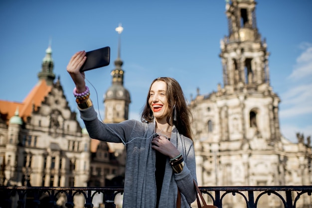 Jonge vrouwentoerist die selfiefoto met telefoon op de oude stadsachtergrond maken in Dresden, Duitsland