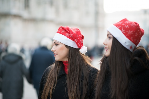 Jonge vrouwenvrienden die samen vóór Kerstmis winkelen