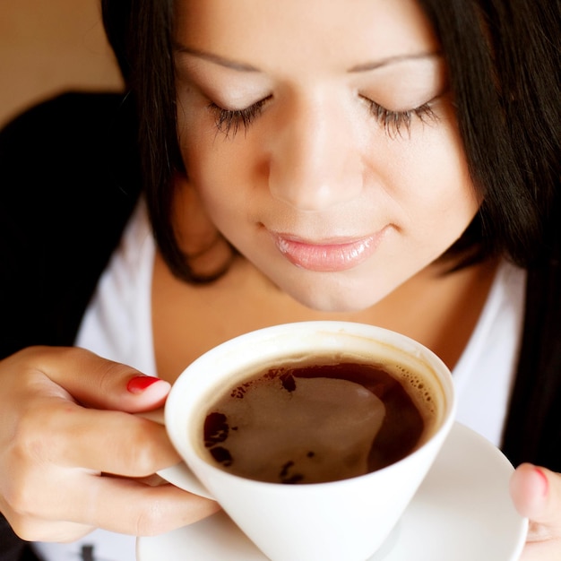 Foto jonge vrouwenzitting in koffie het drinken koffie