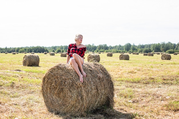 Jonge vrouwenzitting op hooibaal. Hoge kwaliteit foto