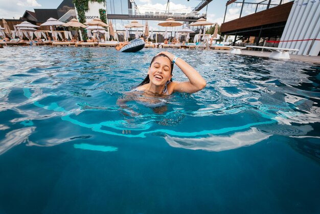 Foto jonge vrouwenzwemmer in blauw poolwater