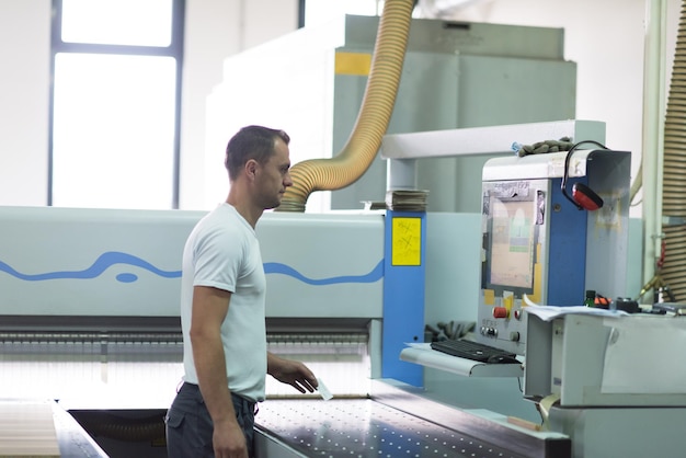 Jonge werknemer werkt in een fabriek voor de productie van houten meubelen