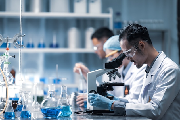 Jonge wetenschapper die door een microscoop in een laboratorium kijkt. Jonge wetenschapper die wat onderzoek doet.