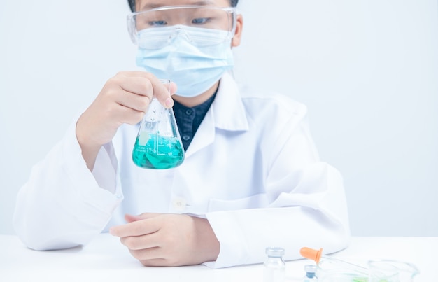 Jonge wetenschappers schudden blauwe vloeibare chemische stof in erlenmeyer geïsoleerd op een witte achtergrond. Wetenschapslaboratorium en onderwijsconcept.