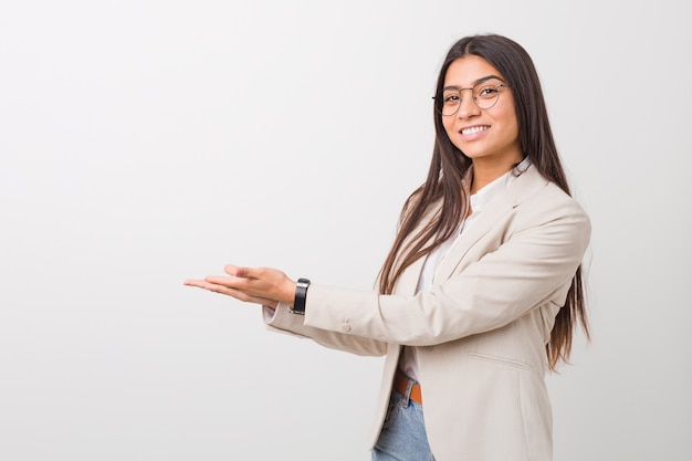 Jonge zakelijke Arabische vrouw geïsoleerd tegen een witte achtergrond met een kopie ruimte op een palm.