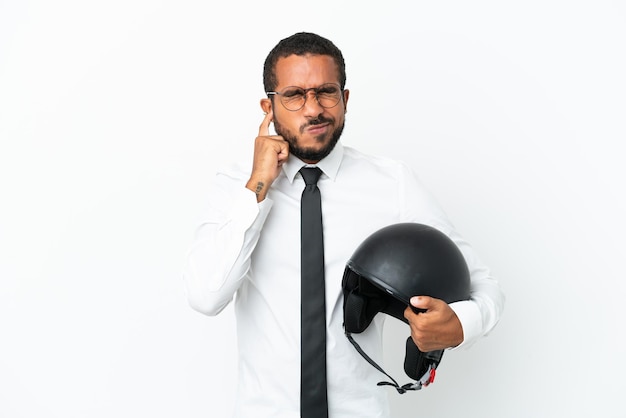 Jonge zakelijke Latijns-man met een motorhelm geïsoleerd op een witte achtergrond gefrustreerd en die oren bedekt