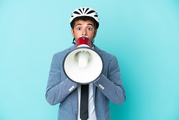 Jonge zaken Braziliaanse man met fietshelm geïsoleerd op blauwe achtergrond schreeuwen door een megafoon