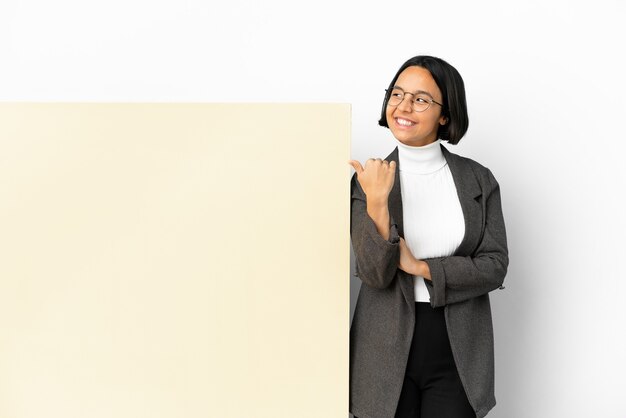 Jonge zaken gemengd ras vrouw met met een grote banner over geïsoleerde achtergrond naar de zijkant te wijzen om een product te presenteren