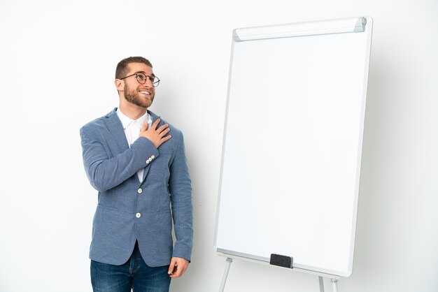 Jonge zaken vrouw die een presentatie geeft op wit bord geïsoleerd op wit opzoeken tijdens het glimlachen