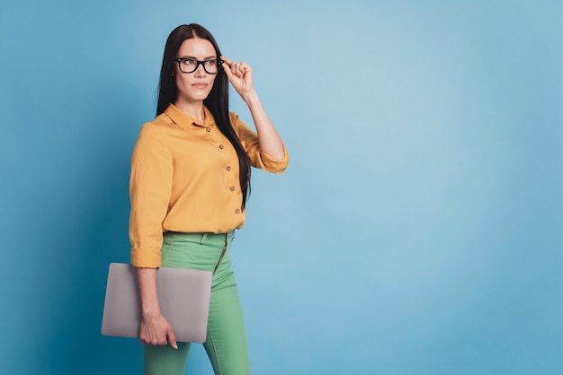 Jonge zakendame met moderne laptop in formalwear op blauwe achtergrond