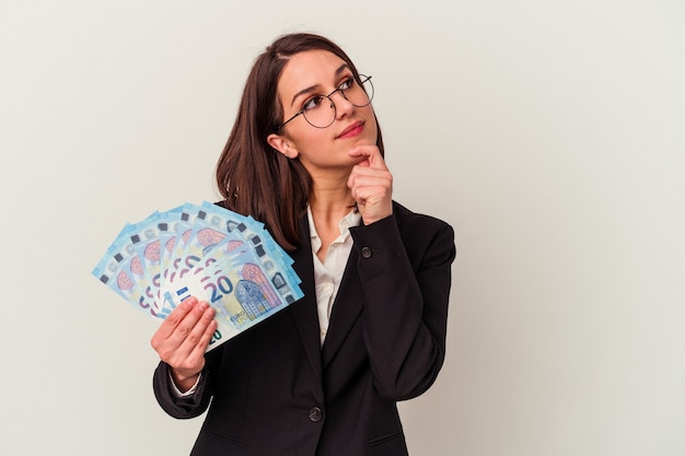 Jonge zakenkaukasische vrouw die rekeningen houdt die op witte achtergrond worden geïsoleerd