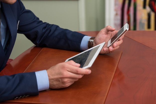 Jonge zakenlieden die touchpad gebruiken tijdens vergadering