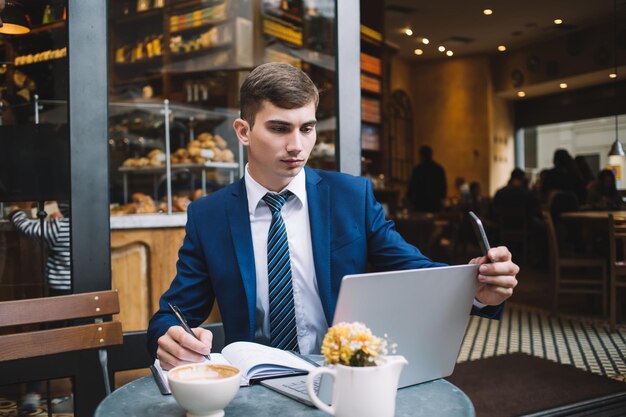 Jonge zakenman die aan laptop in café werkt