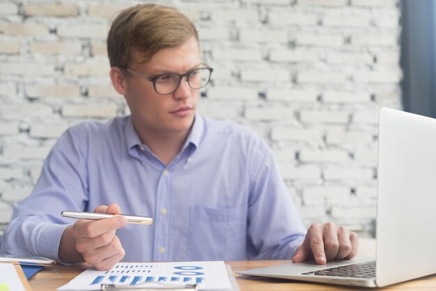 Foto jonge zakenman die aan zijn bureau werkt