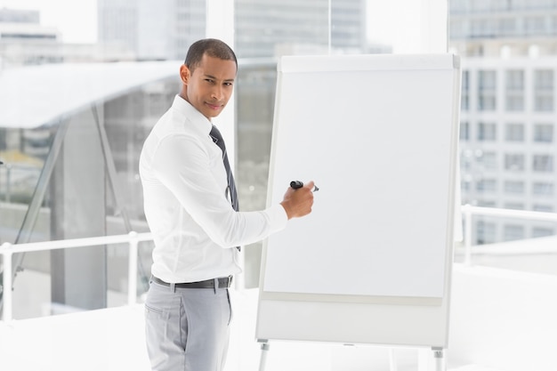 Jonge zakenman die bij whiteboard met teller voorstelt