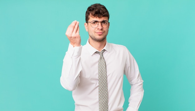 Jonge zakenman die capice of geldgebaar maakt en u vertelt om uw schulden te betalen!