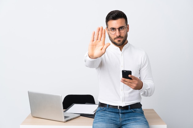 Jonge zakenman die een mobiele telefoon houdt die eindegebaar met haar hand maakt