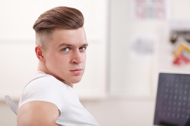 Foto jonge zakenman die op kantoor aan een bureau werkt