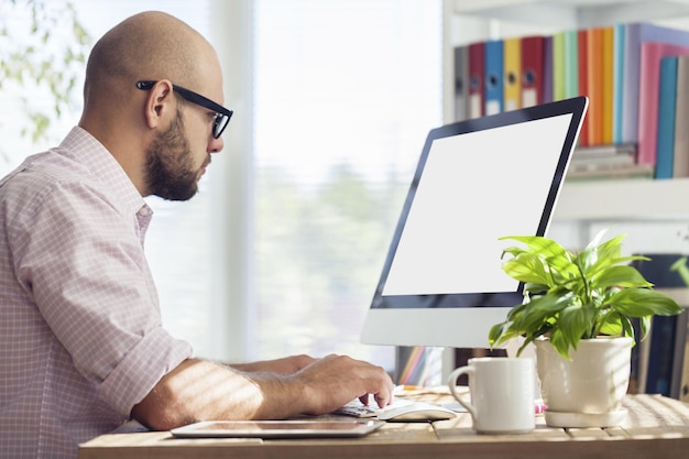 Jonge zakenman die op laptop op kantoor werkt