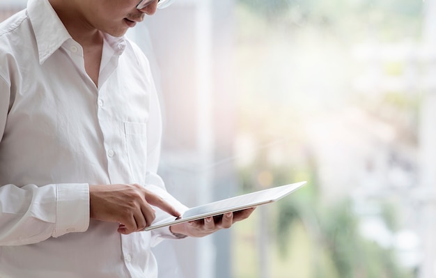 Jonge zakenman die tablet gebruiken terwijl in openlucht status.