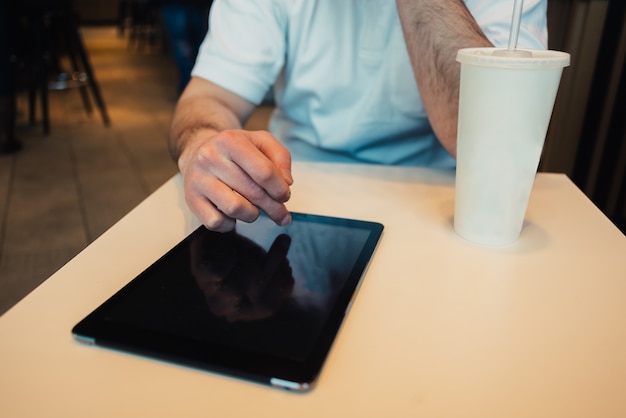 Foto jonge zakenman die tablet in een koffie gebruiken