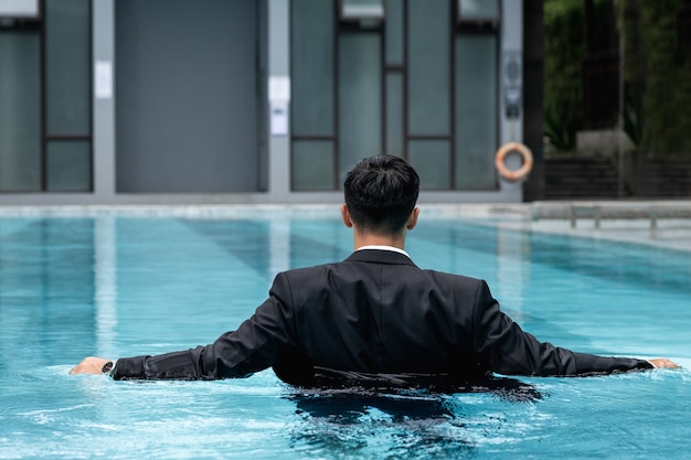 Jonge zakenman die zich in het zwembad bevindt