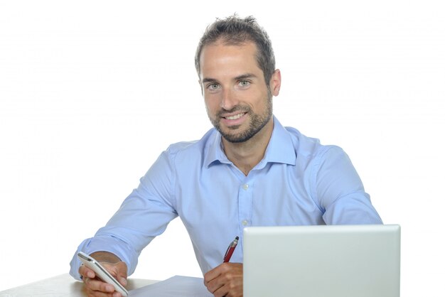 Jonge zakenman die zijn mobiele telefoon in bureau met behulp van.