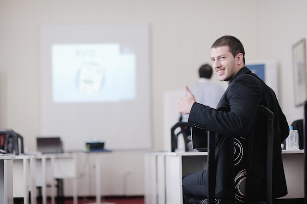 Foto jonge zakenman geeft presentatie en educatieve lessen over seminar evenement in een kleine heldere vergaderzaal