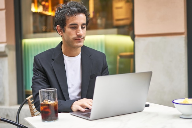 Jonge zakenman hard aan het werk met zijn laptop gericht op het bereiken van zijn doelen