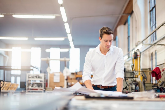 Jonge zakenman in fabriek die aan plan werkt