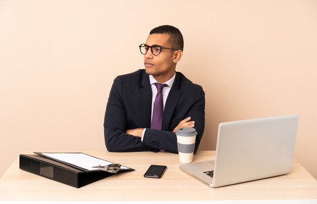 Jonge zakenman in zijn kantoor met een laptop en andere documenten portret