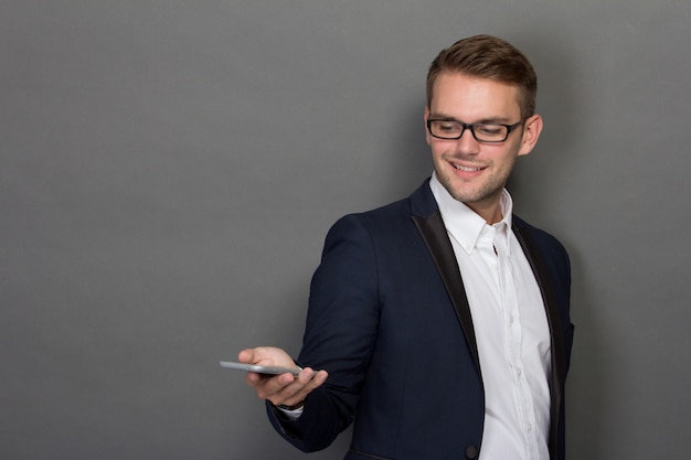 Jonge zakenman met een mobiel op zijn hand