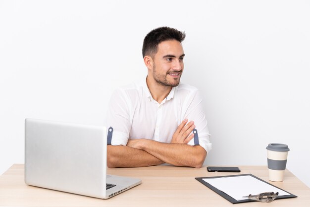 Jonge zakenman met een mobiele telefoon op een werkplek lachen